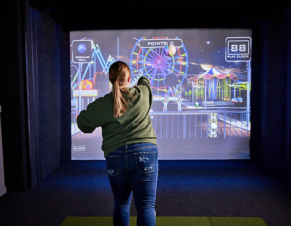 Girl throwing ball at the simulator screen